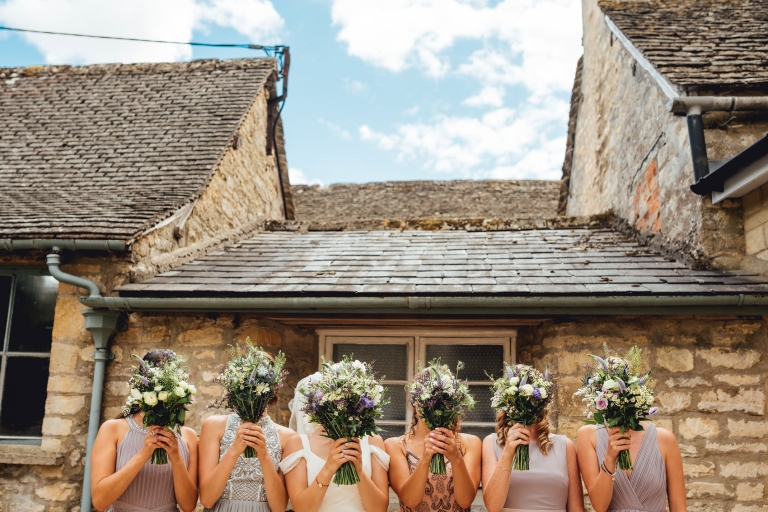 bridesmaids covering faces with flowers silly photo
