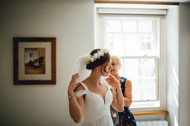 mother of bride helping her daughter get ready