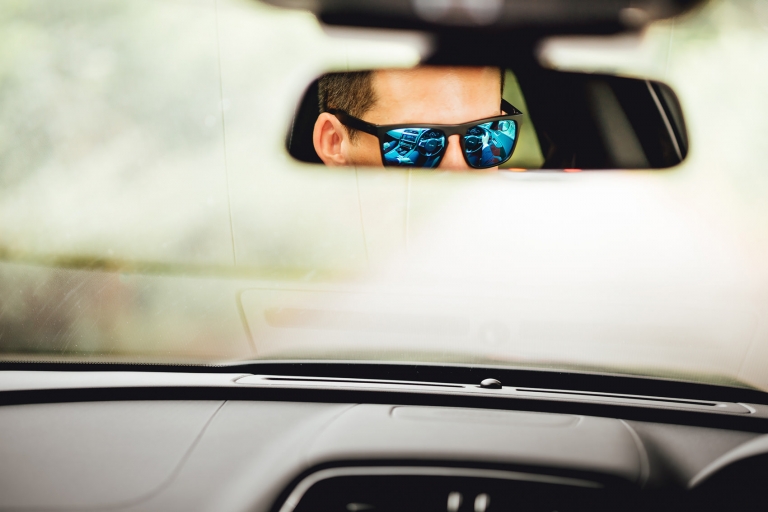 Groomsman looking into rear view mirror